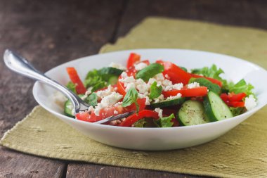 Ahşap arka plan, beyaz bir tabağa Shopska salata yakın çekim