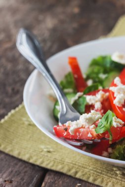 Ahşap arka plan, beyaz bir tabağa Shopska salata yakın çekim