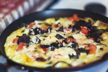 bir tavada ocakta sebzeli omlet