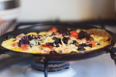 bir tavada ocakta sebzeli omlet