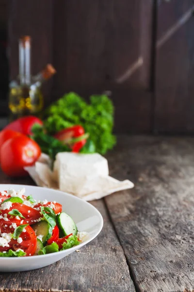 Ahşap arka plan, bir sayı üzerinde beyaz bir tabak içinde Shopska salata 