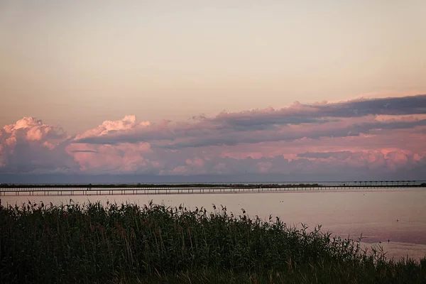 Manzara güzel pembe sunse üzerinde bir deniz örgü uzun köprüden