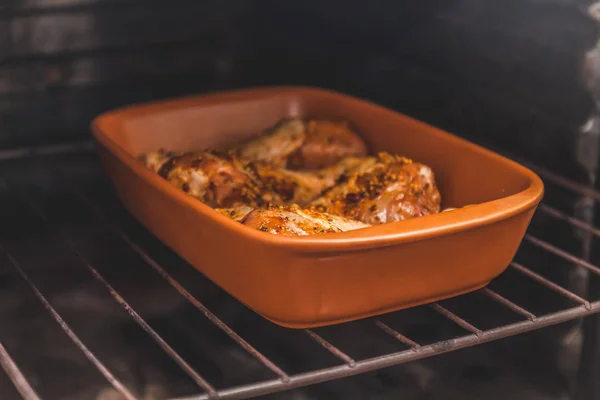 Gemarineerde rauwe kip benen zijn in de oven, retro toning — Stockfoto