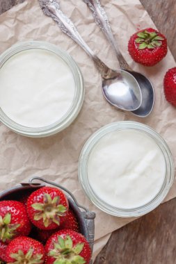 Bir bardak ve bir kova ile taze stra çileklerini yoğurt
