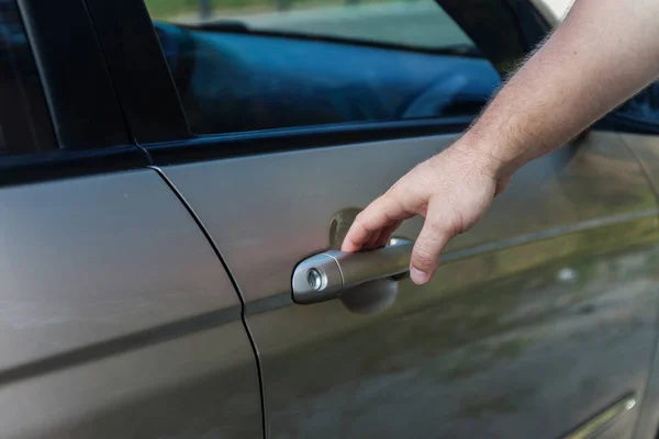 elini arabanın kapısını açar