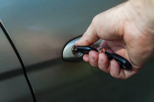Рука людини відкриває двері автомобіля ключем — стокове фото