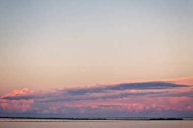 Manzara güzel pembe sunse üzerinde bir deniz örgü uzun köprüden