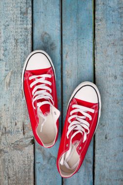 Mavi ahşap arka plan üzerinde kırmızı retro spor ayakkabı