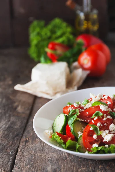 Ahşap arka plan, bir sayı üzerinde beyaz bir tabak içinde Shopska salata 