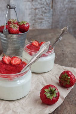 Yoğurt cam ve taze strawberrie bir kova reçel soslu