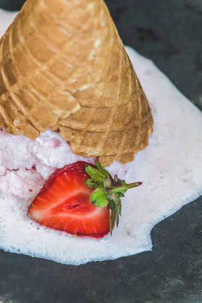 Helado de fresa en un cono de gofre invertido y derretido de nuevo — Foto de Stock