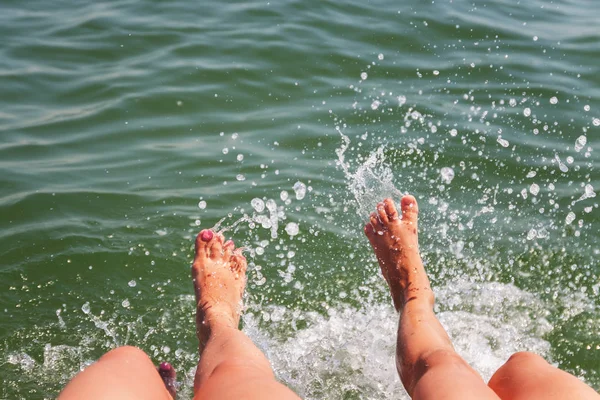 Dos pares de pies chapotean en el agua — Foto de Stock