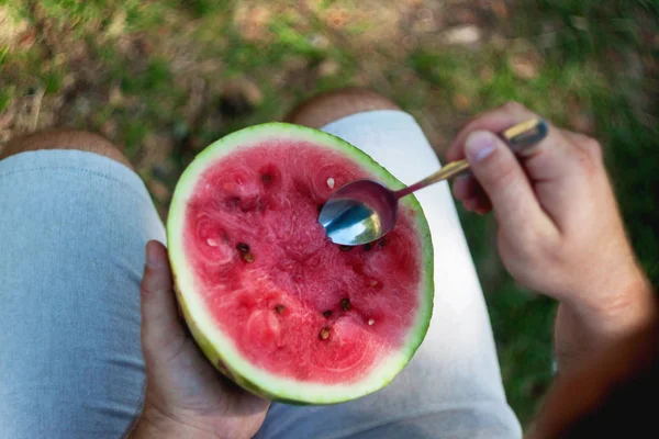 stock image A young man is eating a watermelon with a spoon. The concept of 