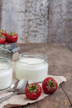 yoğurt bir cam ve bir kova bir woo üzerinde taze çilek ile