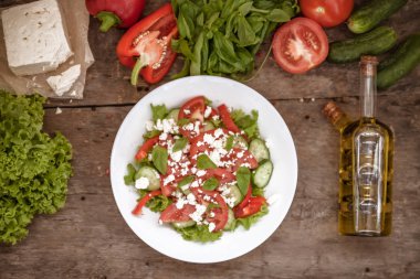 Ahşap arka plan, bir sayı üzerinde beyaz bir tabak içinde Shopska salata 