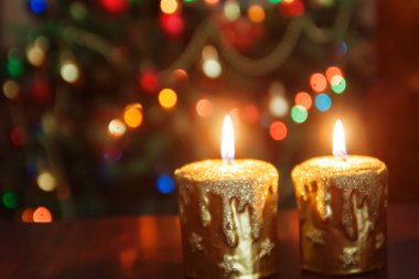 Noel mum parlak lig ile bir Noel ağacı önünde