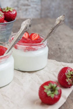 Yoğurt cam ve taze strawberrie bir kova reçel soslu