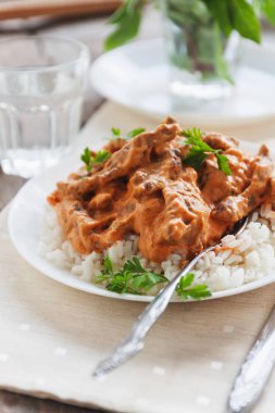 Sığır straganof beyaz tabakta yemek pilav