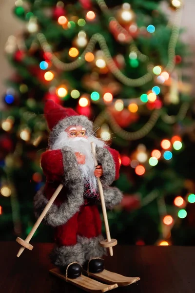 Papai Noel brinquedo traz árvore de Natal no bokeh noite nevada azul — Fotografia de Stock