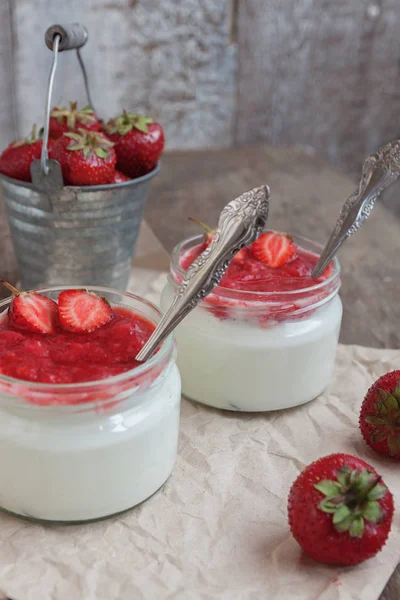 Yogurt with jam sauce in glass and a bucket of fresh strawberrie — Stock Photo, Image