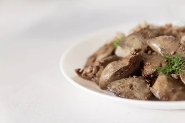 Stewed chicken liver and buckwheat porridge on a white tableclot — Stock Photo, Image