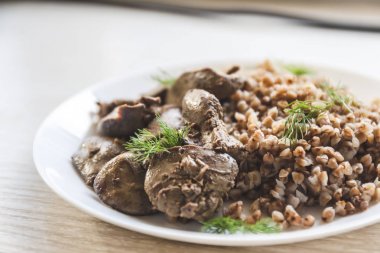 Beyaz bir tableclot üzerinde tavuk karaciğer ve buğday lapası Komposto