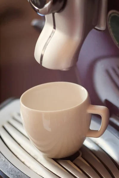 Vit kopp stående på gallret av kaffemaskin med kaffe — Stockfoto