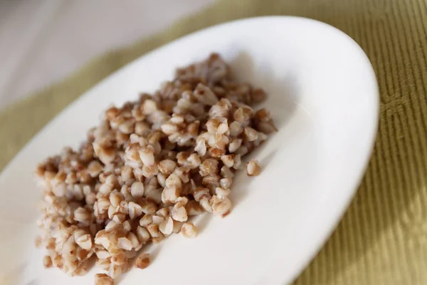 Gachas de trigo sarraceno en plato sobre fondo blanco con sombra — Foto de Stock