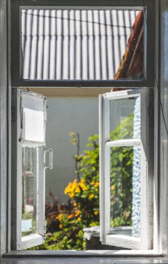 Güneşli yaz avluda bir eski kırsal penceresinden görüntülemek