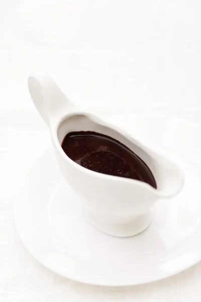 Шоколадный соус в белом фарфоровом соусе на белом бэкгре — стоковое фото