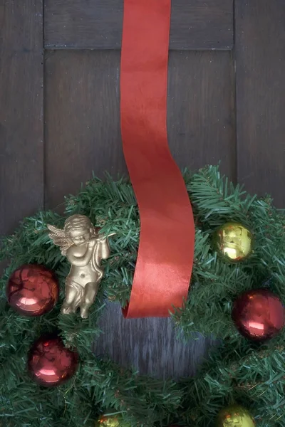 在一个木制的房子的门上的圣诞花环 — 图库照片