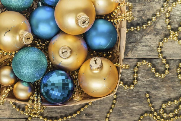 Blue Christmas balls and gold, beads lie in a wooden basket top — Stock Photo, Image