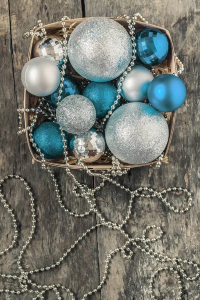 Blue Christmas balls en zilver, kralen liggen in een houten mand aan — Stockfoto