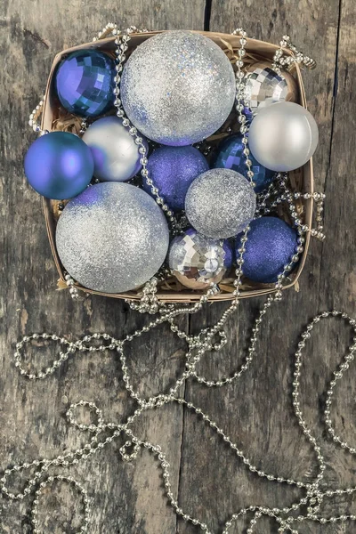 Paarse kerstballen en zilver, kralen liggen in een houten mand — Stockfoto