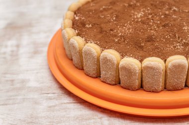 Yuvarlak tiramisu pasta kakao powd serpin Beyaz ahşap masa üzerinde