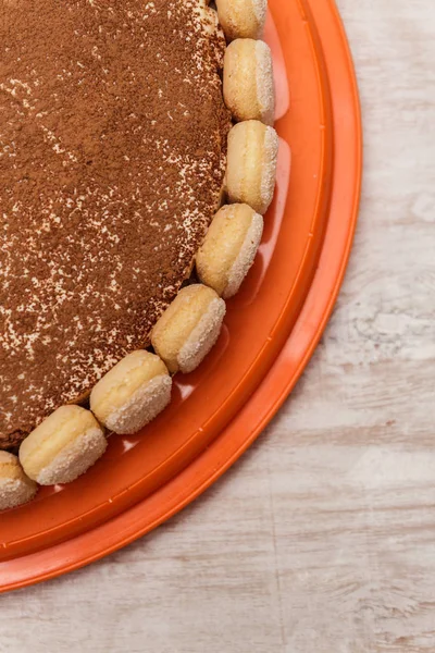 Круглый торт тирамису на белом деревянном столе посыпать какао порошок — стоковое фото