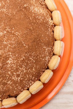 Yuvarlak tiramisu pasta kakao powd serpin Beyaz ahşap masa üzerinde