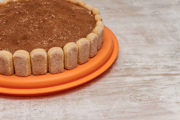 Круглый торт тирамису на белом деревянном столе посыпать какао порошок — стоковое фото