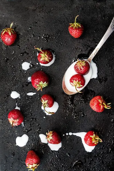 Sobre un fondo húmedo oscuro derramado de una cucharada de yogur y s — Foto de Stock