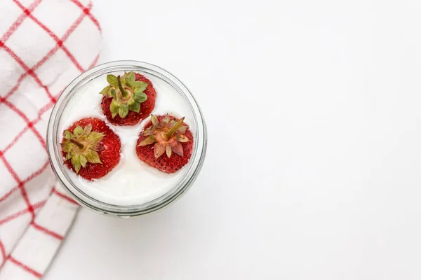 Postre yogur y capas de fresa en un vaso sobre una franja roja —  Fotos de Stock