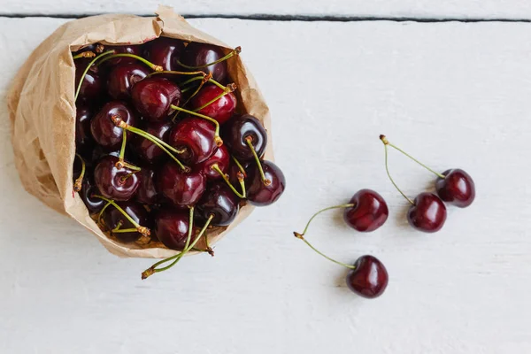 Taze kiraz çilek üzerinde beyaz bir backgro izole bir kağıt torba