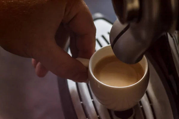 Copo branco de pé na grade da máquina de café com café — Fotografia de Stock