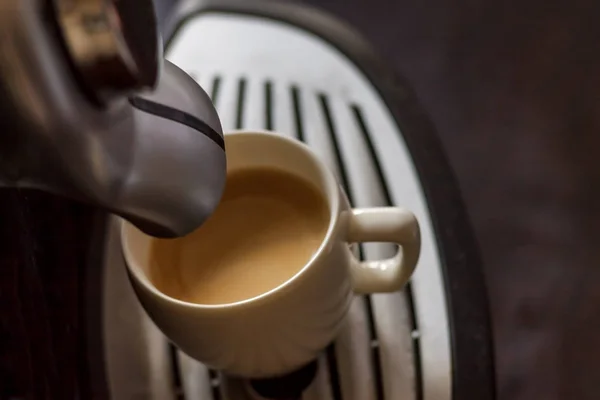 Copa blanca de pie en la rejilla de la máquina de café con café — Foto de Stock