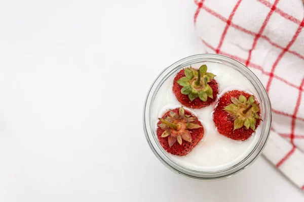 Postre yogur y capas de fresa en un vaso sobre una franja roja —  Fotos de Stock