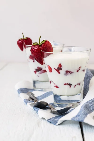 Couches de yaourt et de fraises dans un verre sur une bande bleue — Photo