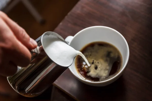 Homem derramando em uma xícara de café com leite — Fotografia de Stock