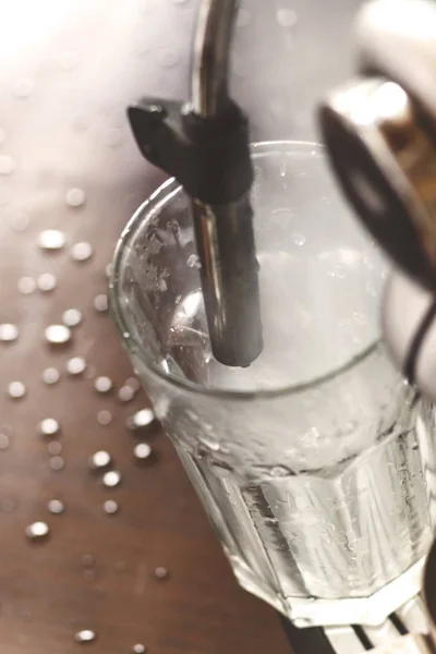 Professional bartender warming milk for cappuccino. Barista usin