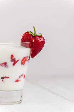 Tatlı yoğurt ve çilek katmanları bir cam üzerinde mavi bir şerit