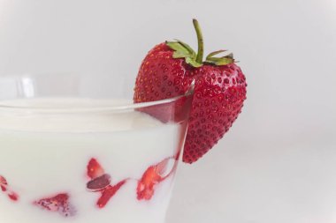 Tatlı yoğurt ve çilek katmanları bir cam üzerinde mavi bir şerit