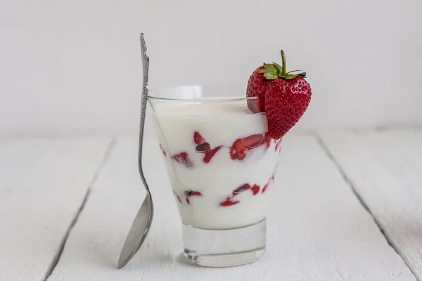 Dessert-Joghurt und Erdbeerschichten im Glas auf blauem Streifen — Stockfoto